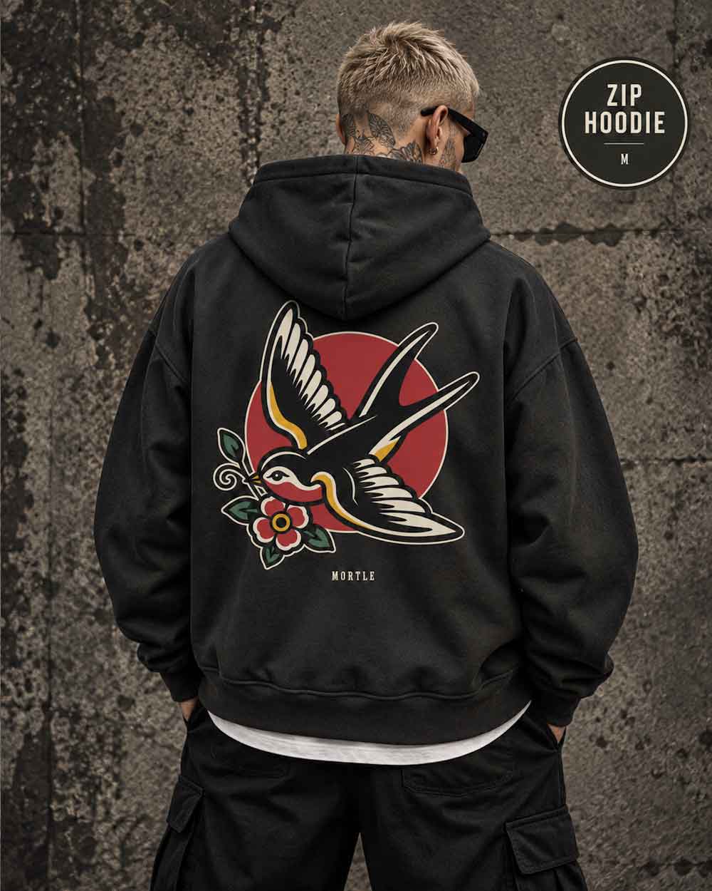 Männliches Model trägt schwarzen MORTLE Swallow Oversized Zip Hoodie mit großem Tattoo Backprint
