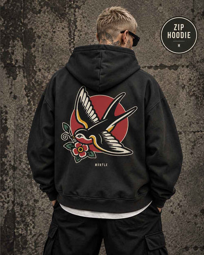 Männliches Model trägt schwarzen MORTLE Swallow Oversized Zip Hoodie mit großem Tattoo Backprint